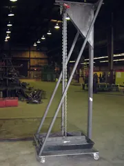 Upton's clam shell dump stand on the shop floor, with its chain and sludge collection tray on casters