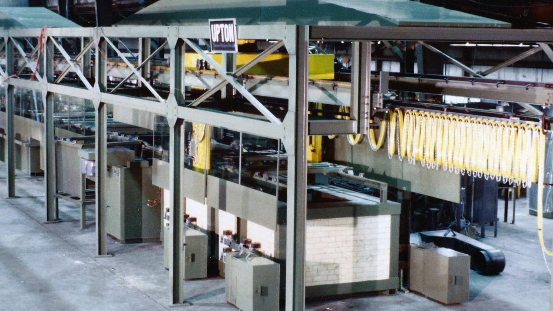 Upton's automated salt bath line on a shop floor, with the UPTON sign hanging from the gantry